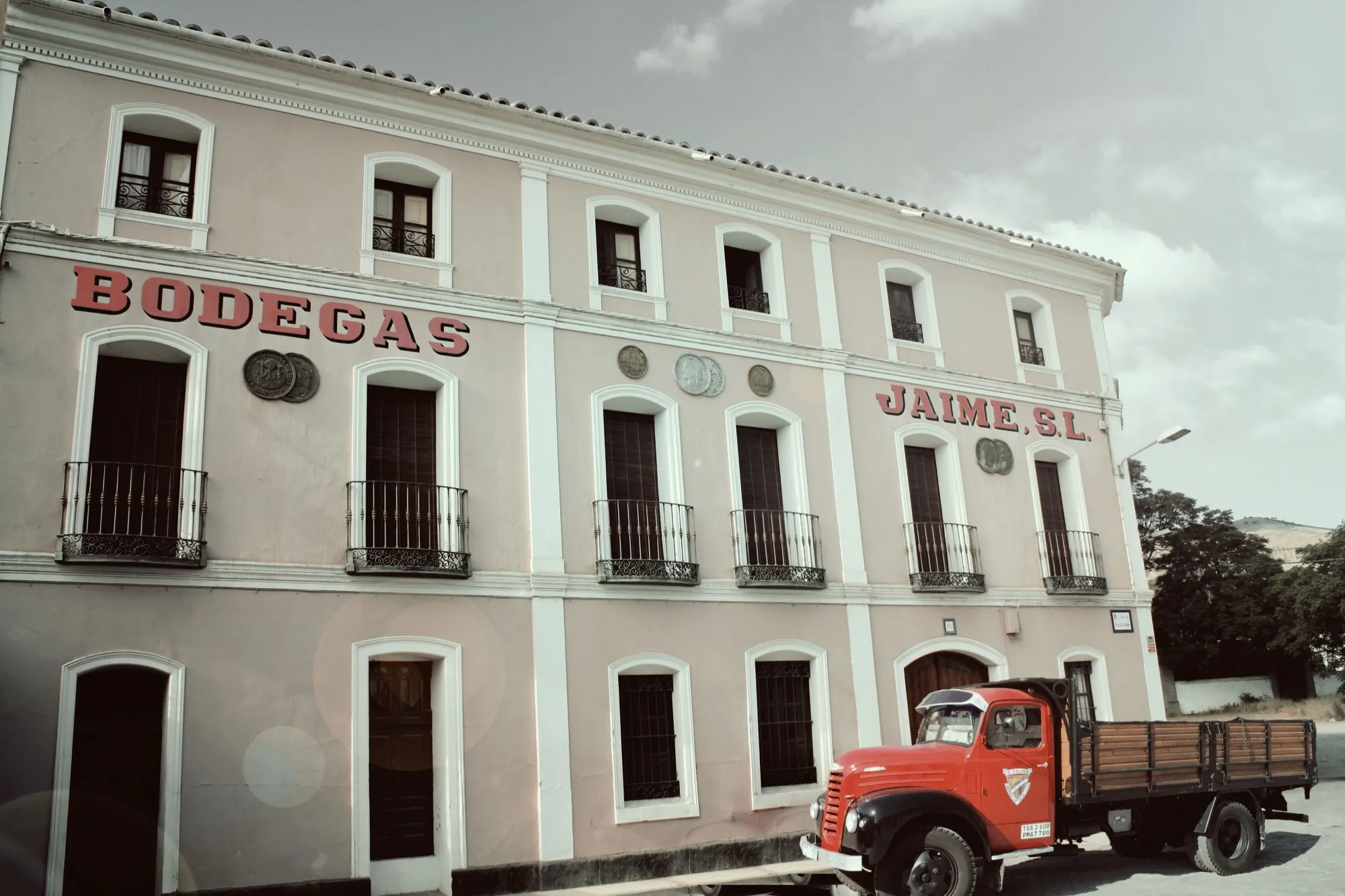 Fachada de la bodega con un antiguo camión de reparto